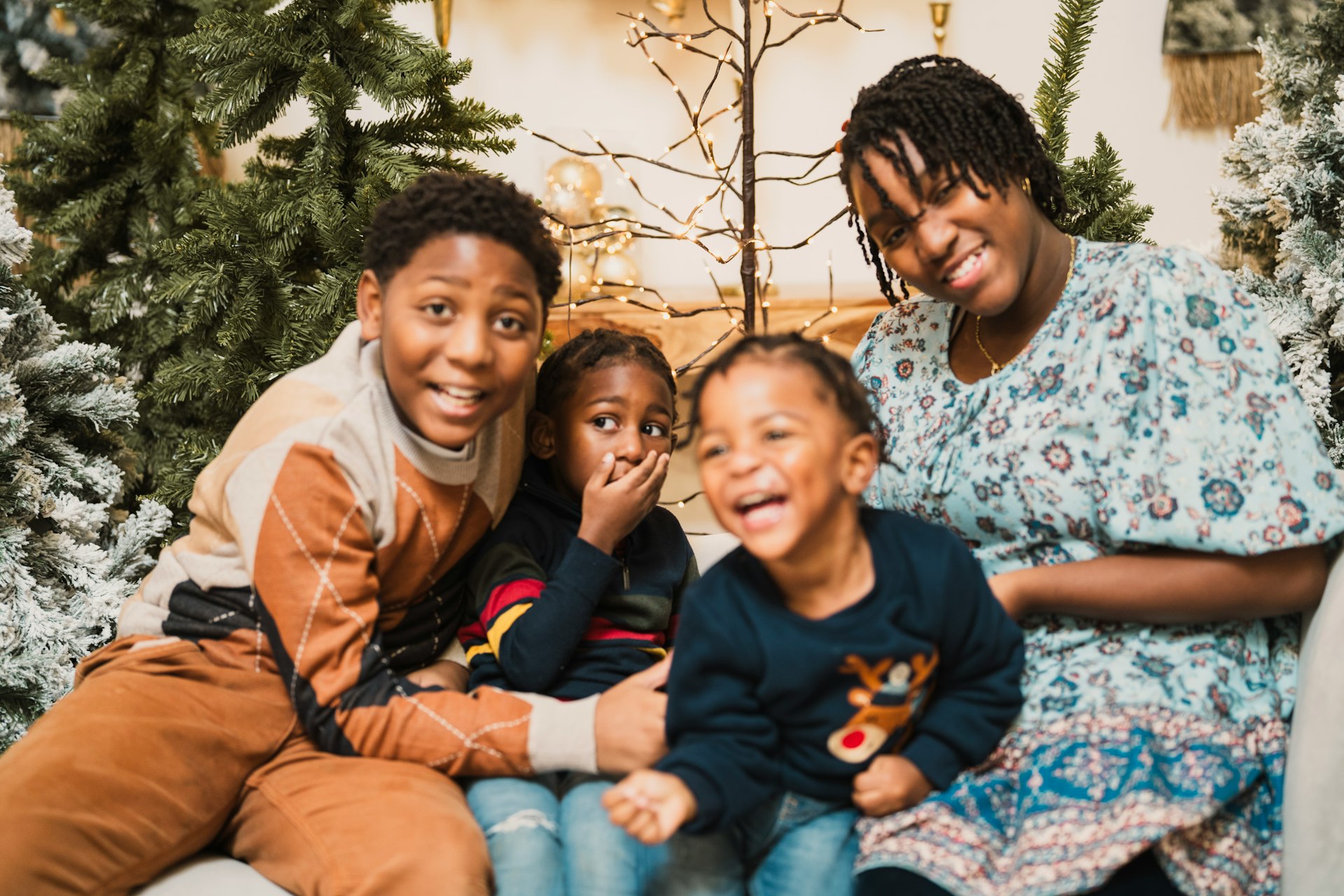 a family sitting on a couch in front of a christmas tree